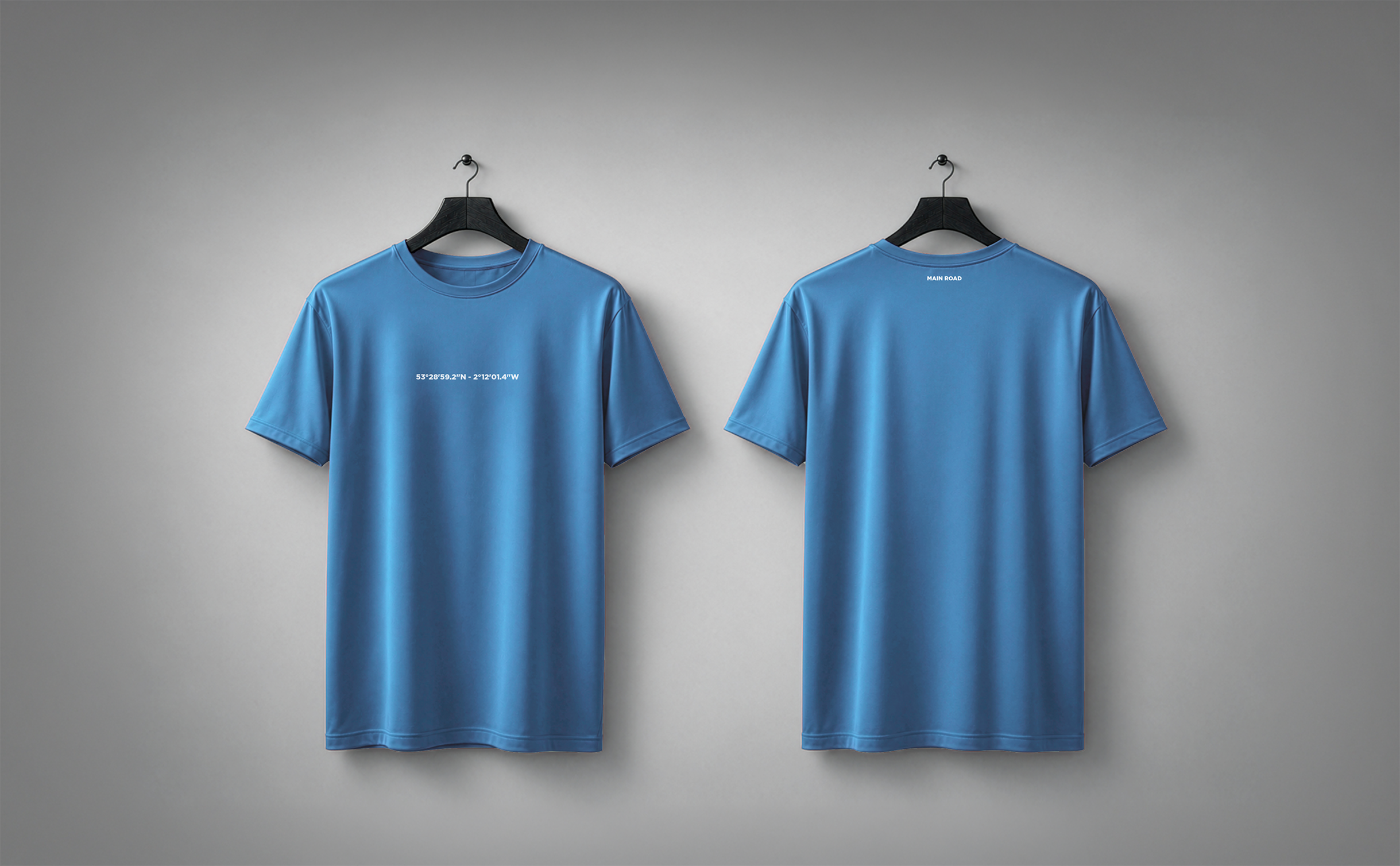 Sky blue STADIA T-shirt shown from the front and back, carrying the coordinates and name of Main Road.